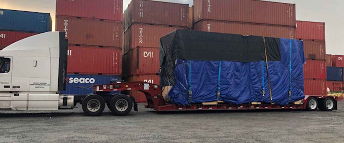 Large shipping container loaded onto Geva trailer truck