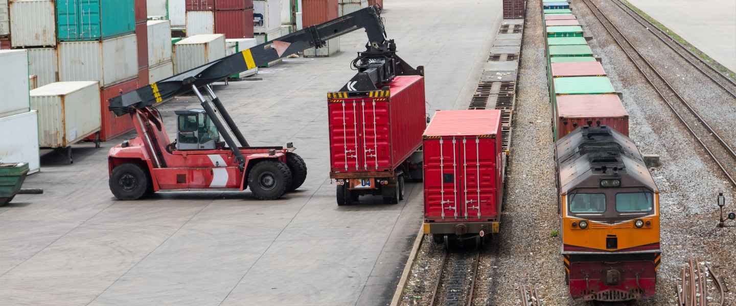 Lifter loader loading shipping container onto truck