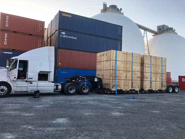 Geva Logistics trailer truck next to several shipping containers